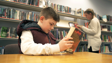 Boy reading in library