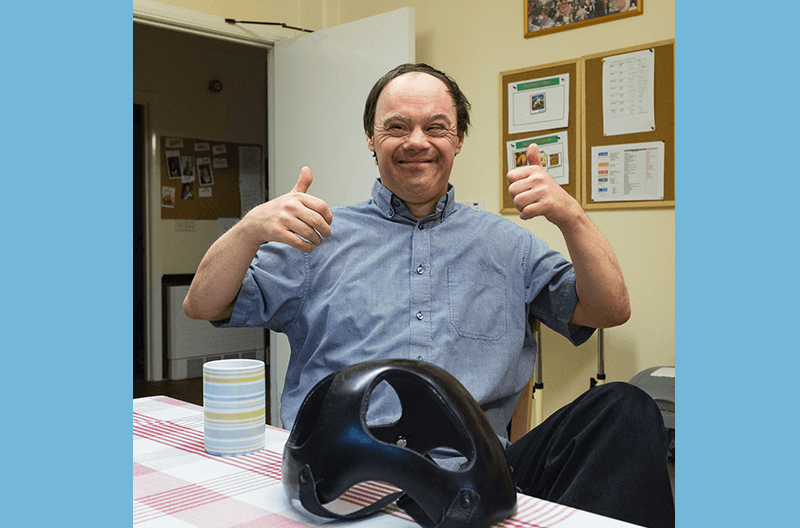 man smiling with his thumbs up